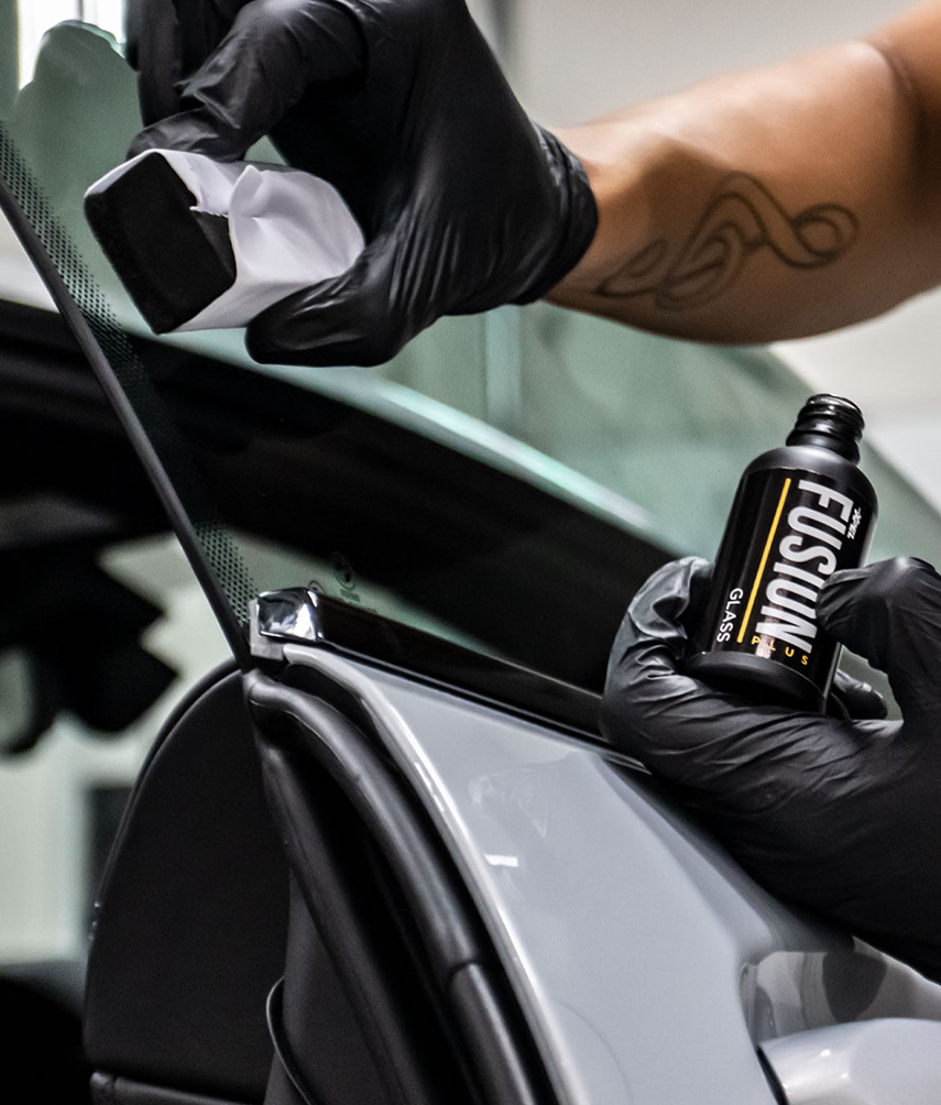 Applying XPEL Fusion ceramic coating to the window of a car