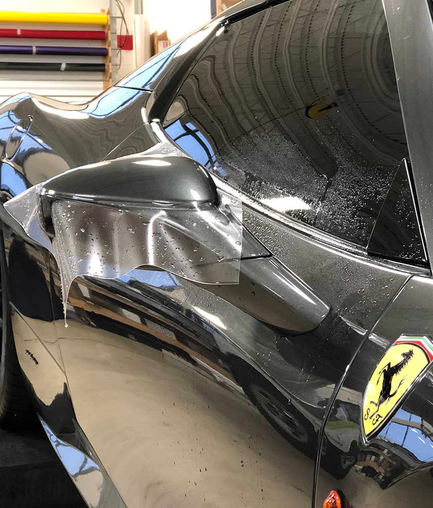 Appling XPEL PPF paint protection film to black car